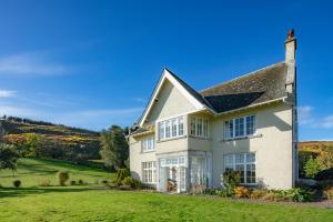 ein weißes Haus mit grünem Rasen in der Unterkunft Yearle House in Wooler