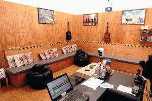 a room with a couch and a table with a laptop at Aotea Hostel Iquique in Iquique