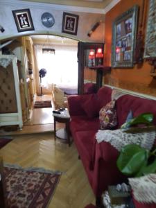 - un salon avec un canapé rouge et une table dans l'établissement كورنيش المعادي, au Caire