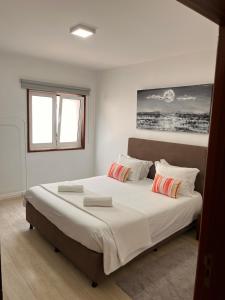 Un dormitorio con una cama grande con dos almohadas. en Casa da Vila Guest House, en Póvoa de Varzim