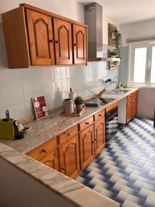 uma cozinha com armários de madeira e piso em azulejo em Casa da Vila Guest House na Póvoa do Varzim