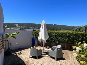 un patio con sombrilla, 2 sillas y una mesa en Casa da Vila Guest House, en Póvoa de Varzim