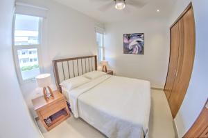 a small bedroom with a bed and a window at Pavilion 2BR Golden Zone - 1 Block to Beach in Bucerías