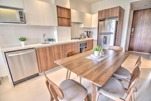 a kitchen with a wooden dining table and chairs at Pavilion 2BR Golden Zone - 1 Block to Beach in Bucerías