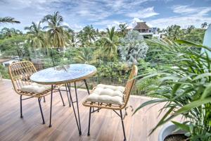 a table and chairs on a balcony with palm trees at Pavilion 2BR Golden Zone - 1 Block to Beach in Bucerías