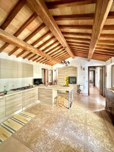 a large kitchen with wooden ceilings and a table at La Casetta in Orvieto Scalo