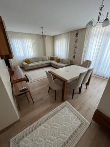 ein Wohnzimmer mit einem Tisch, Stühlen und einem Sofa in der Unterkunft Luxury Apartment In The Center 7 Min Walking Distance to Metrobus in Esenyurt