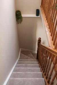 a staircase in a house with a wooden stair case at Cosy Lake District Cottage in Staveley