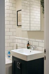 une salle de bains avec un lavabo blanc et un miroir dans l'établissement Cosy Lake District Cottage, à Staveley