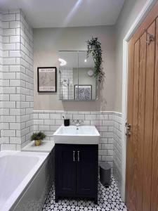 a bathroom with a tub and a sink and a bath tub at Cosy Lake District Cottage in Staveley