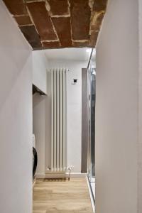a hallway with white walls and a ceiling with a window at Casa Monelli in Siena