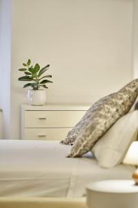 Una cama con almohadas y una maceta. en Casa Monelli, en Siena