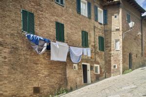 a clothes line with underwear hanging in front of a brick building at Casa Monelli in Siena