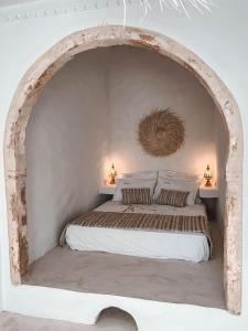 1 dormitorio con 1 cama grande y un arco en Dar Naël en Houmt El Souk