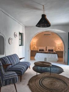 a bedroom with a bed and a couch and a table at Dar Naël in Houmt Souk