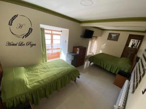 a bedroom with two beds and a sign on the wall at Hostal Los Pozos in Potosí