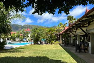 伊頓島的住宿－Eden Island (GIE Apartment)，享有游泳池的景色,位于一个以山脉为背景的度假胜地