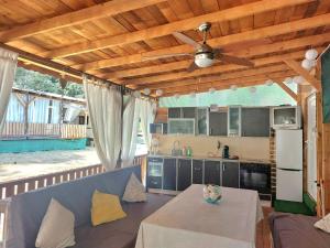 a kitchen with a table and a ceiling fan at Каравана Summer time in Chernomorets