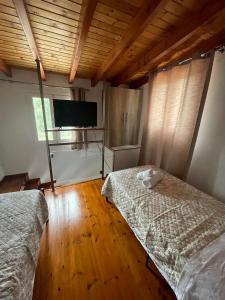 um quarto com 2 camas e uma televisão de ecrã plano em Villa Mitsialis em Lakka