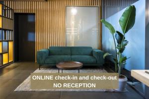 un vestíbulo de oficina con un sofá verde y una señal de no recepción en 6532 Smart Hotel - Self check-in, en Arbedo-Castione