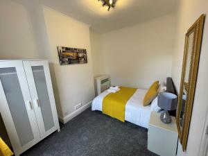 a small bedroom with a bed and a mirror at Robinhuts - 3 Bed Accommodation -Perfect for Contractors, Families & Students in Hull