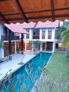 a villa with a swimming pool in front of a house at Elshape Holiday VILLA in Masjid Tanah