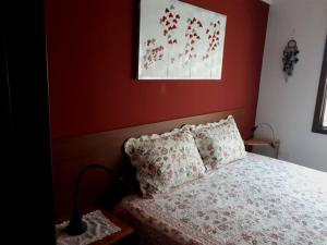 Un dormitorio con una cama con una pared roja. en Apartamento tranquilo en una casa con jardín, en La Laguna
