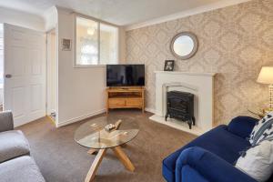 a living room with a blue couch and a fireplace at Host & Stay - Pearl Street in Saltburn-by-the-Sea