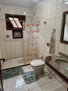 a bathroom with a toilet and a shower and a sink at Casa do SOL in Guarapari