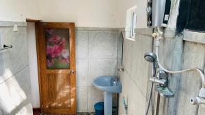 baño con puerta de madera y lavamanos en Sisira Natural Lodge - Sigiriya, en Sigiriya