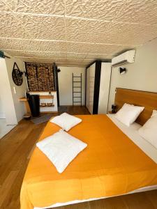 ein Schlafzimmer mit einem großen Holzbett mit weißen Kissen in der Unterkunft Le gite de Dylan in Valréas