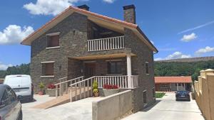une maison en briques avec un balcon dans une allée. dans l'établissement El Mirador de la LLeira, à Ferreras de Arriba