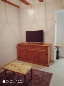 a living room with a flat screen tv on a wooden cabinet at Apartamento con encanto Ripalda VALENCIAYOLE in Valencia