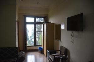 a living room with a tv and a window at Eagle Nest, Malam Jabba by LMC in Swat