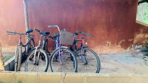 Tres motos están estacionadas junto a una pared. en Sisira Natural Lodge - Sigiriya, en Sigiriya