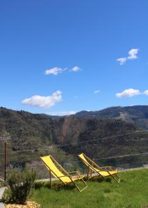 dos sillas amarillas sentadas en la cima de una colina en I profumi del bosco, en Enego