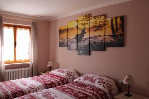 1 dormitorio con 1 cama y algunos cuadros en la pared en I profumi del bosco, en Enego