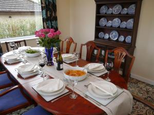 a dining room table with plates and dishes on it at Braidwood in Castle Douglas