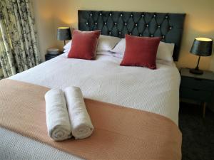 a bedroom with a large bed with towels on it at Braidwood in Castle Douglas