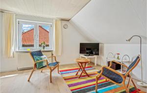 uma sala de estar com cadeiras, uma mesa e uma televisão em 1 Bedroom Cozy Apartment In Ringkbing em Ringkøbing