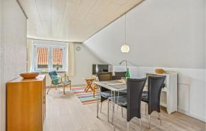 a dining room and living room with a table and chairs at 1 Bedroom Cozy Apartment In Ringkbing in Ringkøbing