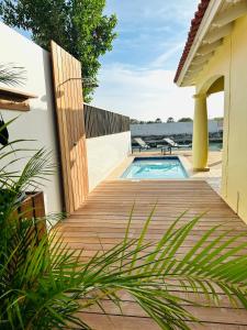 a wooden deck with a swimming pool on a house at Kas Manta Watervillas in Kralendijk