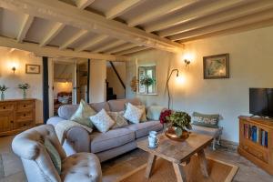 a living room with a couch and a table at Finest Retreats - Manor Cottage in Winterborne Stickland