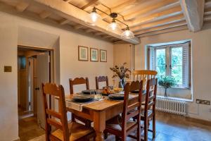a dining room with a wooden table and chairs at Finest Retreats - Manor Cottage in Winterborne Stickland