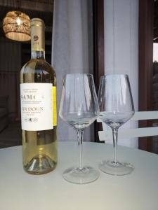 uma garrafa de vinho e dois copos de vinho numa mesa em Valia's Beach House em Samos