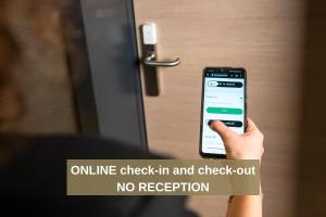 an image of a person holding a cell phone in front of a door at 6532 Smart Hotel - Self check-in in Arbedo-Castione