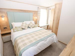 a bedroom with a large bed and a window at 7 Wild Haven in Landford