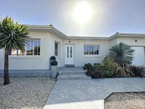 a white house with a palm tree in front of it at Villa Nolaene, 8-9 pers, Piscine, Calme et Moderne in Gujan-Mestras