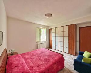 sypialnia z różowym łóżkiem i niebieską kanapą w obiekcie Villa D'Agati w mieście San Giorgio