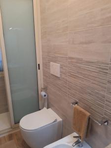 La salle de bains est pourvue de toilettes blanches et d'un lavabo. dans l'établissement Appartamento In Riva Al Mare con Posto Auto E Disponibilità Bicicletta, à Mascali